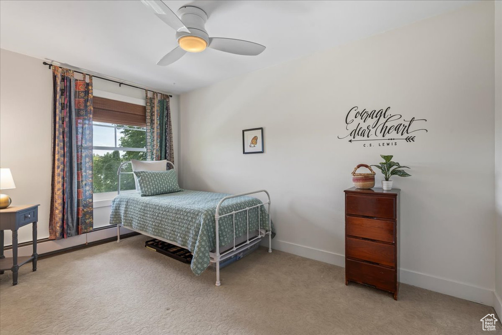 Carpeted bedroom with baseboards and a ceiling fan