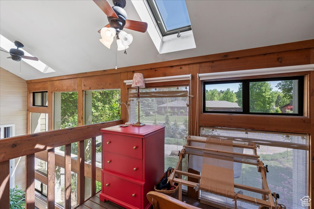 Sunroom / solarium with a skylight, vaulted ceiling, and healthy amount of natural light