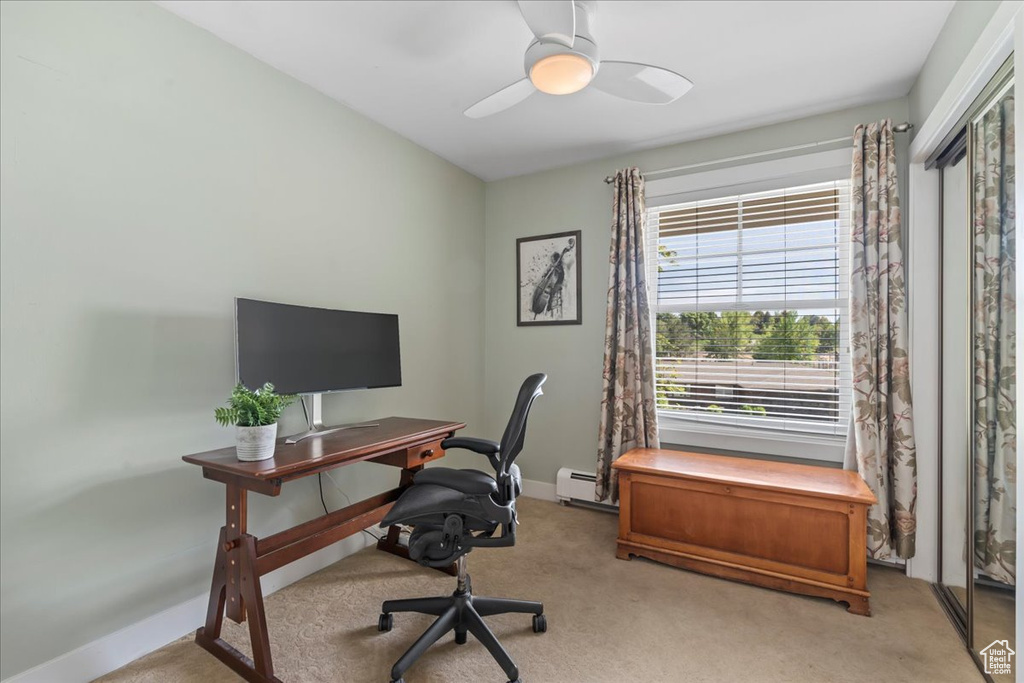 Office space featuring healthy amount of natural light, carpet floors, a ceiling fan, and baseboards