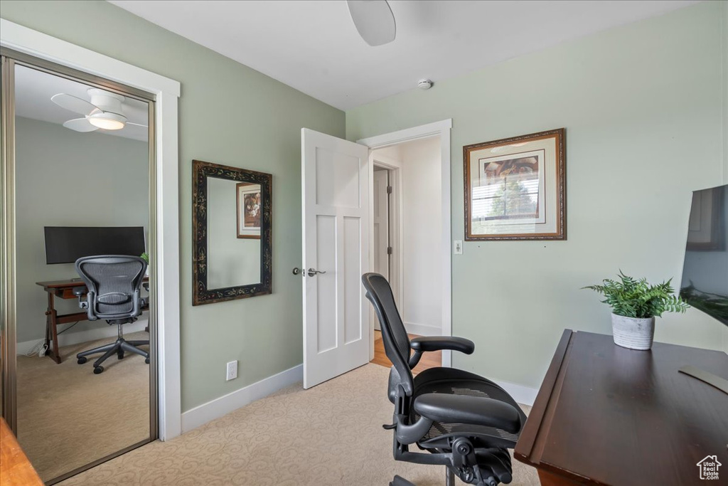 Office area with light colored carpet, baseboards, and ceiling fan