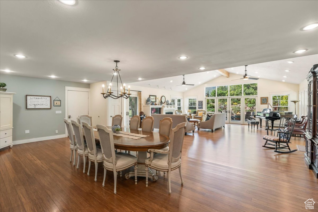 Dining room with dark wood finished floors, baseboards, recessed lighting, a chandelier, and french doors