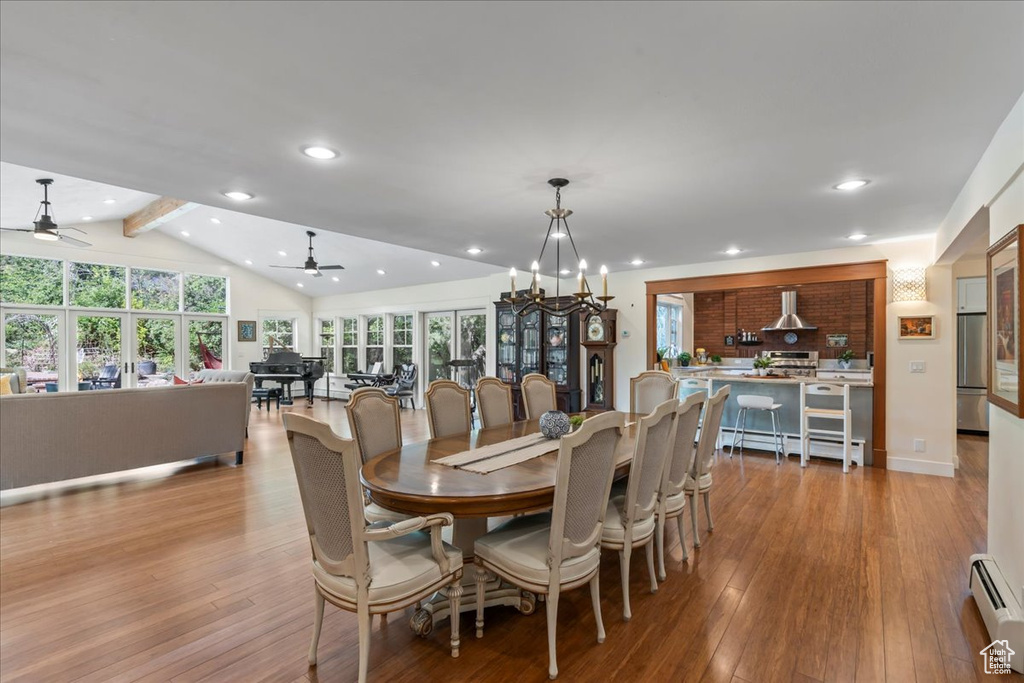 Dining space with a ceiling fan, baseboard heating, hardwood / wood-style flooring, recessed lighting, and a chandelier