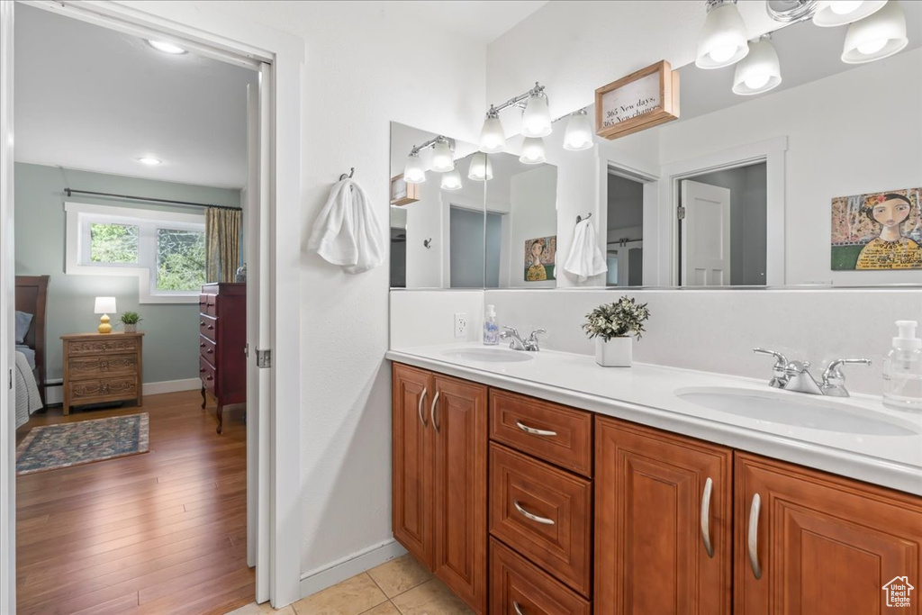 Full bath with double vanity, baseboards, ensuite bathroom, and a baseboard heating unit
