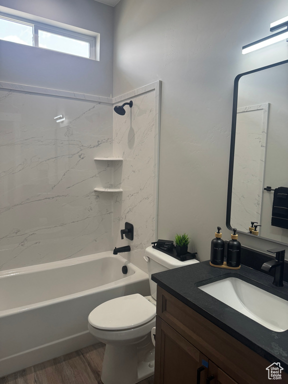 Full bathroom featuring vanity, wood finished floors, toilet, and shower / washtub combination