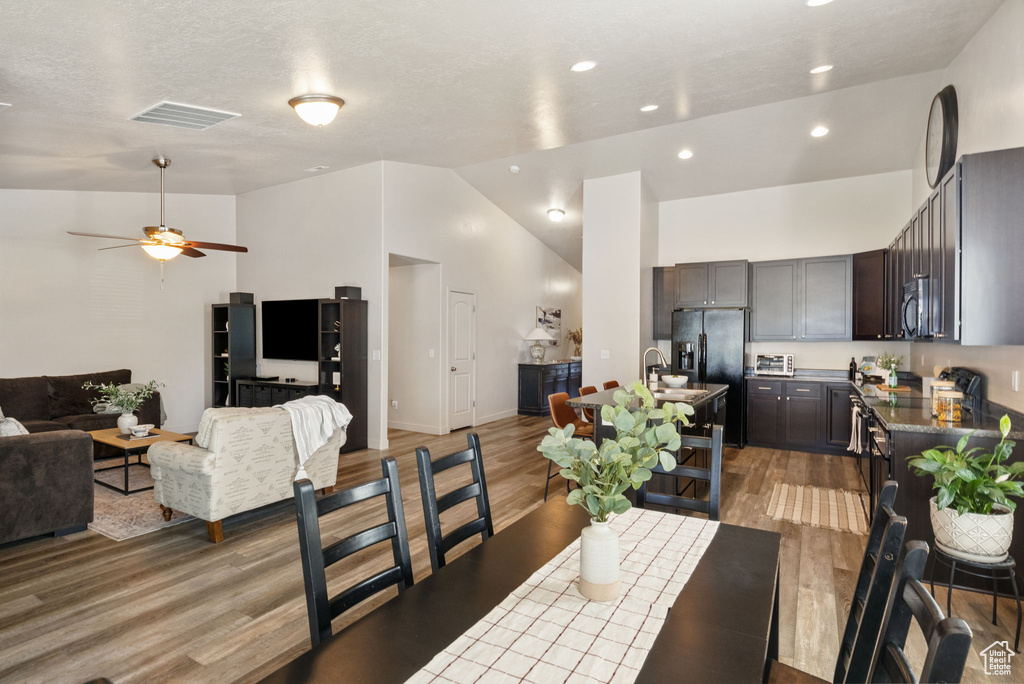 Dining room featuring lofted ceiling, light wood finished floors, ceiling fan, and recessed lighting
