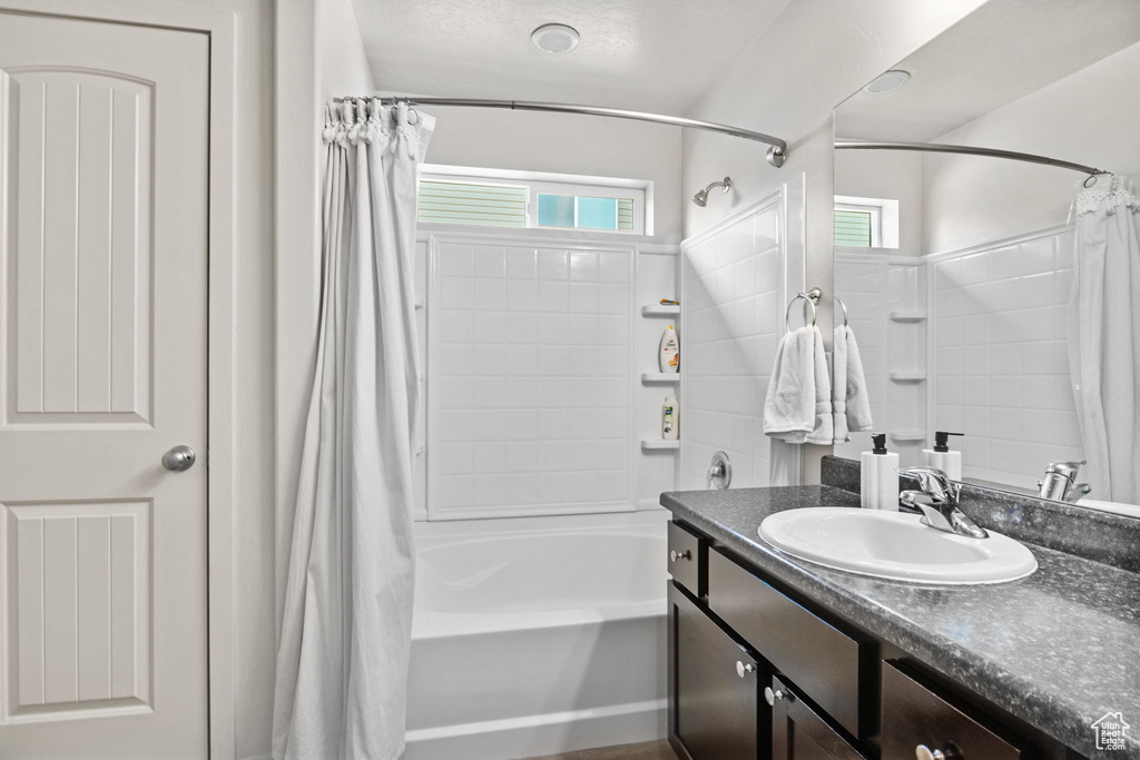 Full bathroom featuring shower / bath combo with shower curtain and vanity