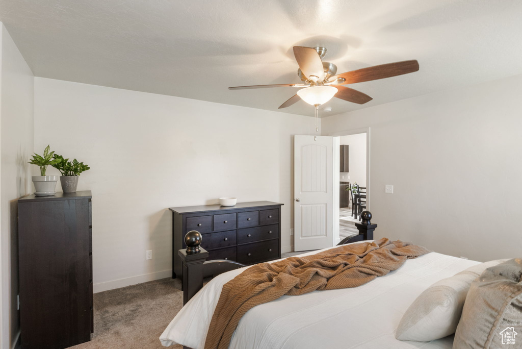Carpeted bedroom featuring baseboards and ceiling fan