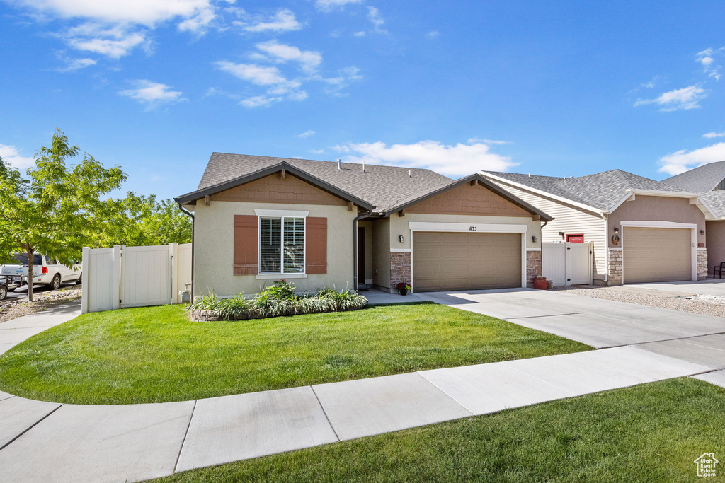Single story home featuring an attached garage, a gate, concrete driveway, and stucco siding