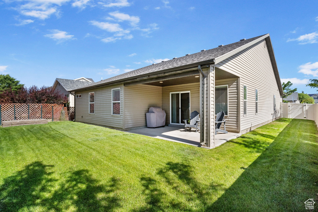 Rear view of property featuring a patio area and a gate