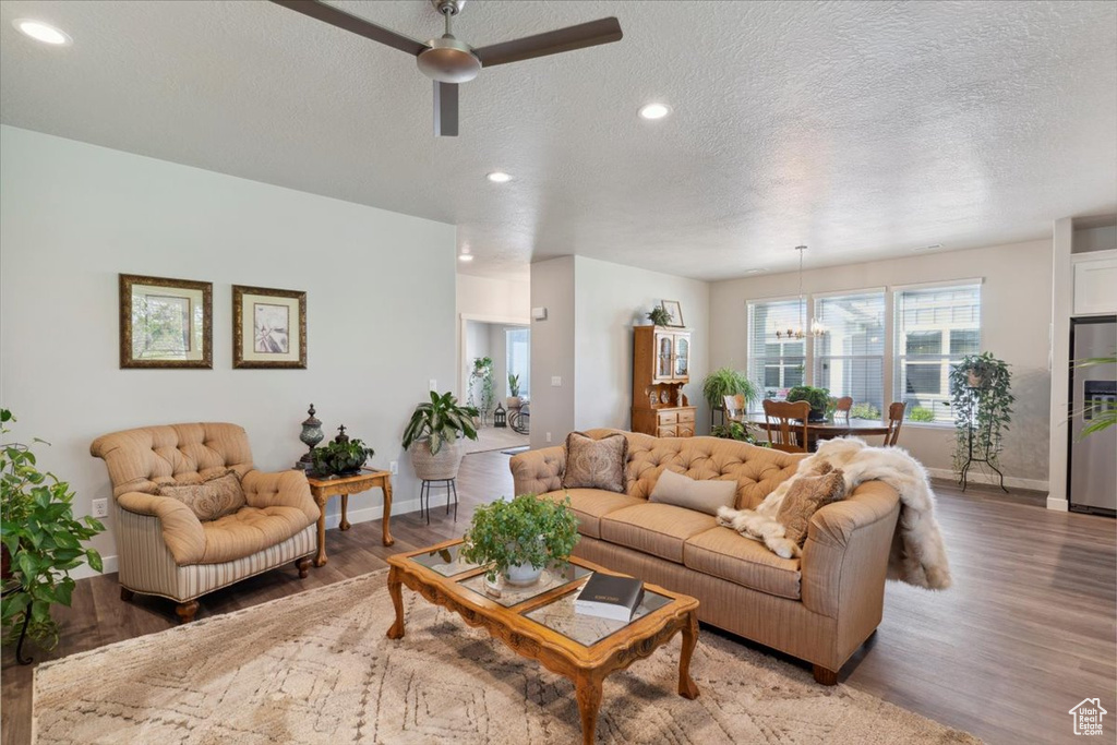 Living area featuring a ceiling fan, light wood-type flooring, a textured ceiling, baseboards, and recessed lighting