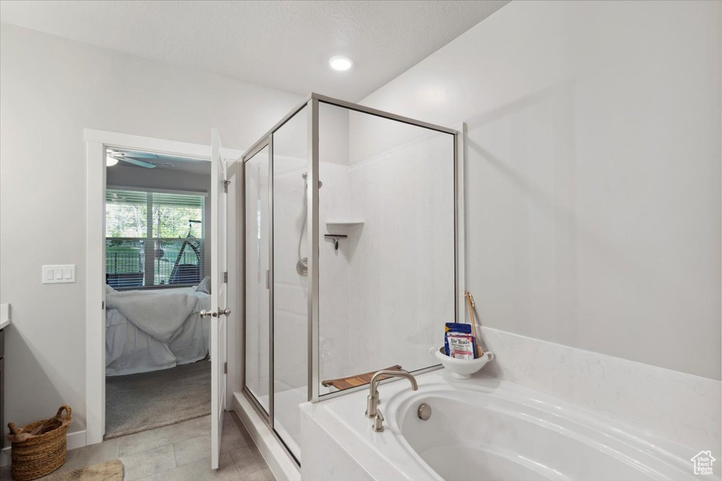 Ensuite bathroom featuring a bath, a shower stall, and vanity