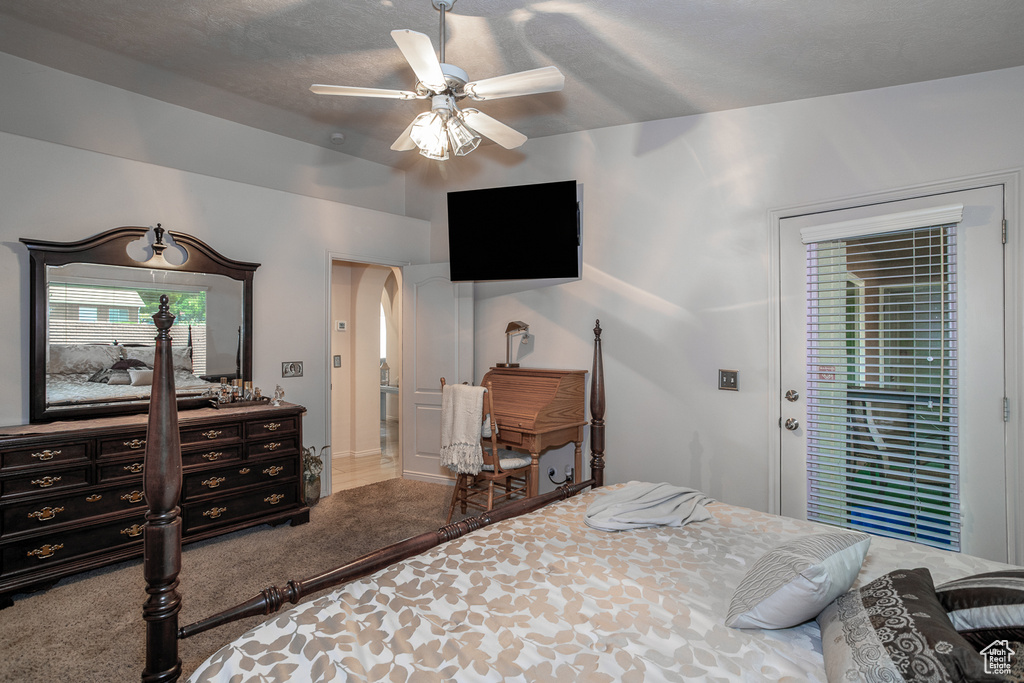 Bedroom featuring access to exterior, a ceiling fan, carpet flooring, and arched walkways