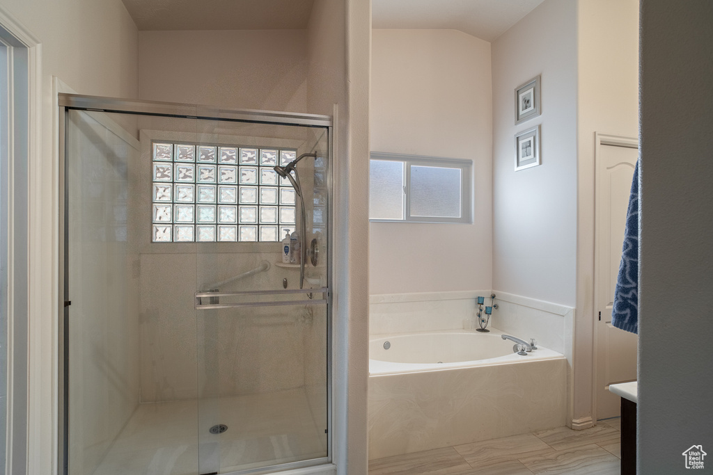 Bathroom with a shower stall, vanity, a garden tub, and plenty of natural light
