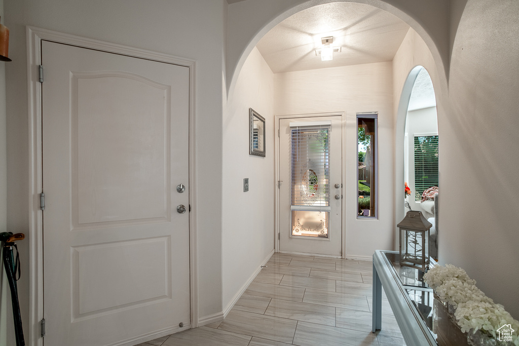 Foyer featuring baseboards and arched walkways