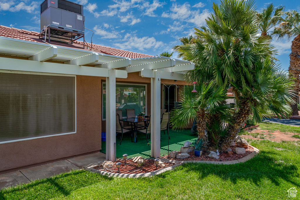 Exterior space featuring a pergola, stucco siding, a patio area, and a yard