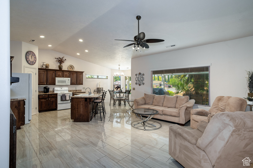 Living area featuring a ceiling fan, recessed lighting, a chandelier, vaulted ceiling, and light marble finish floors
