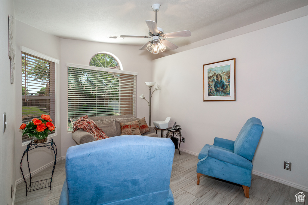 Living area featuring baseboards and ceiling fan