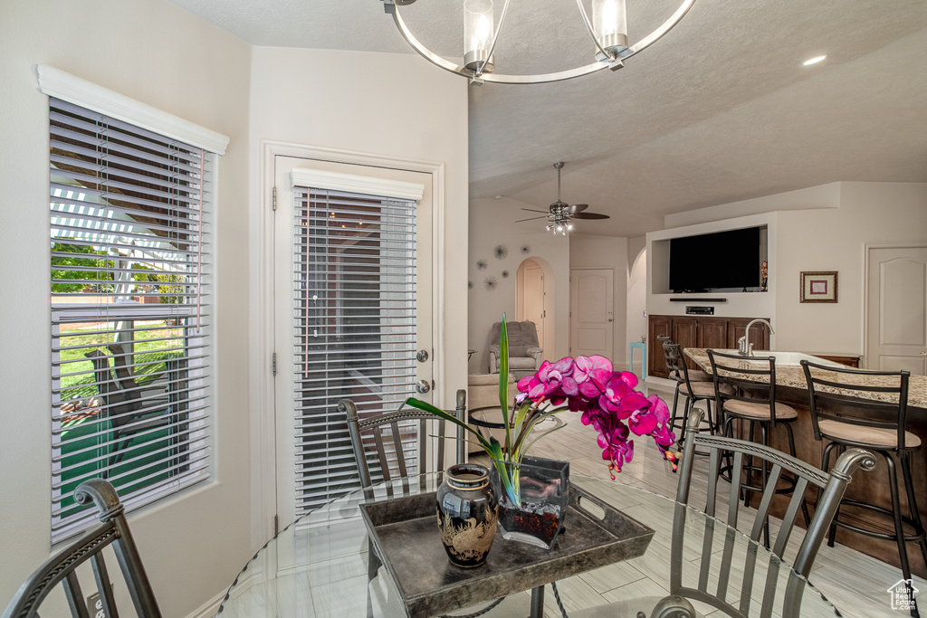 Dining space with arched walkways and a ceiling fan