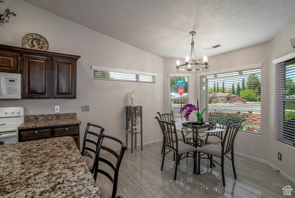 Dining area with a chandelier and baseboards