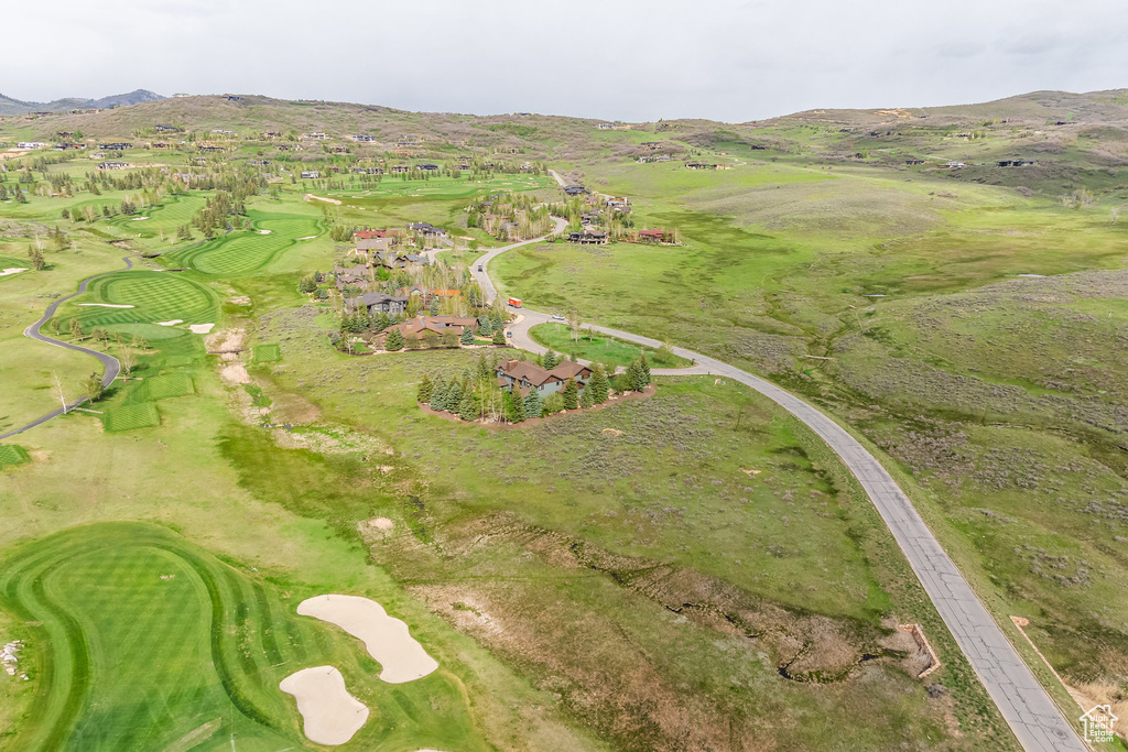 Aerial view of property's location with a mountain backdrop and a local golf course