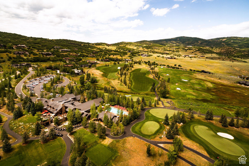 Aerial overview of property's location featuring a mountain backdrop and a golf course
