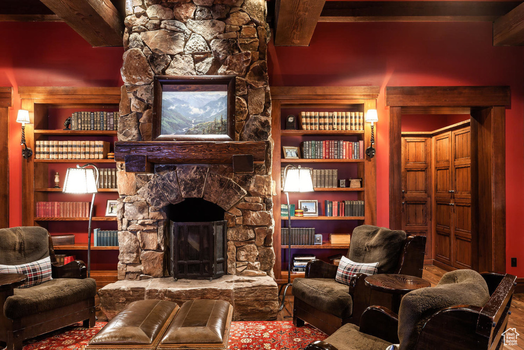 Living room with a fireplace, beamed ceiling, and wood finished floors