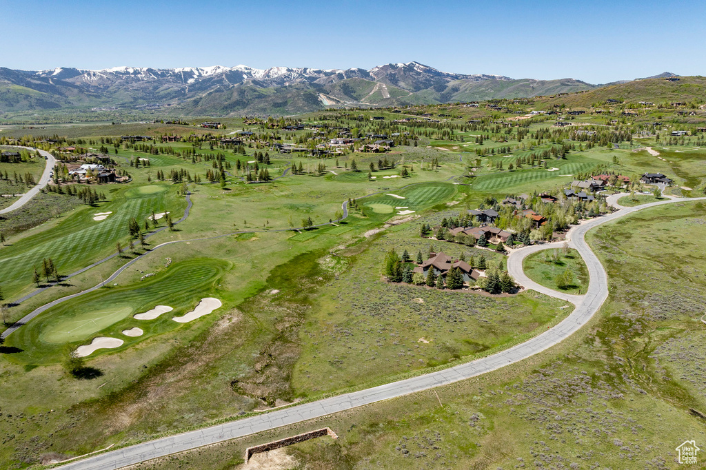 Aerial view of property's location featuring a mountainous background and a golf course