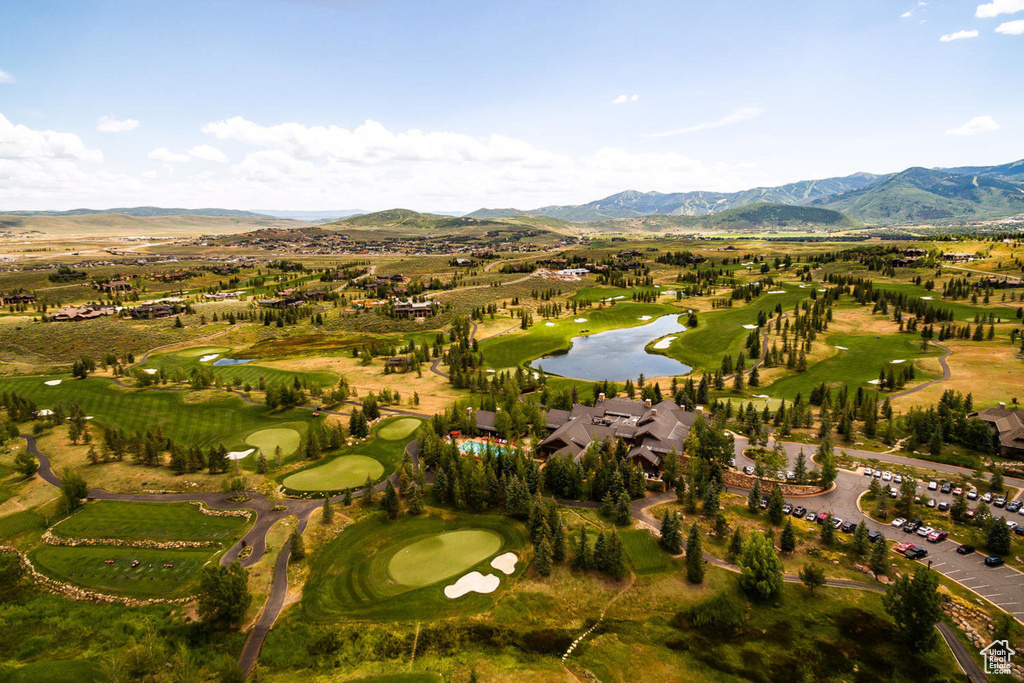 Aerial view of property's location featuring a golf club and a water and mountain view
