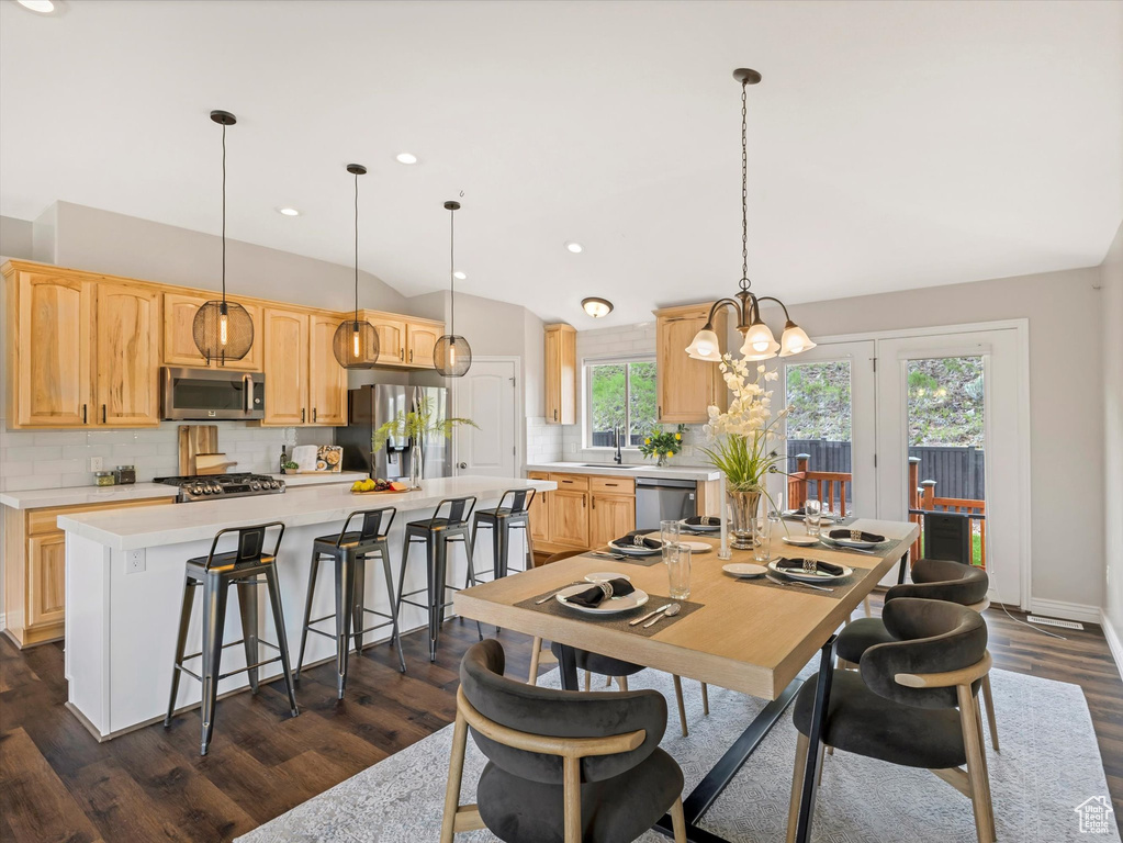 Dining room featuring dark wood-style flooring, vaulted ceiling, a chandelier, recessed lighting, and baseboards