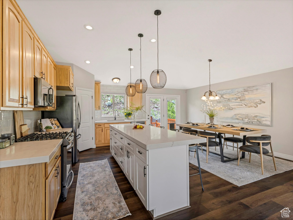 Kitchen featuring a center island, dark wood-type flooring, tasteful backsplash, light countertops, and recessed lighting
