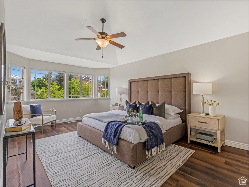 Bedroom featuring baseboards, multiple windows, and wood finished floors