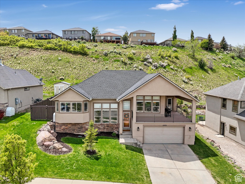 View of front of home featuring stucco siding, a garage, concrete driveway, and a residential view