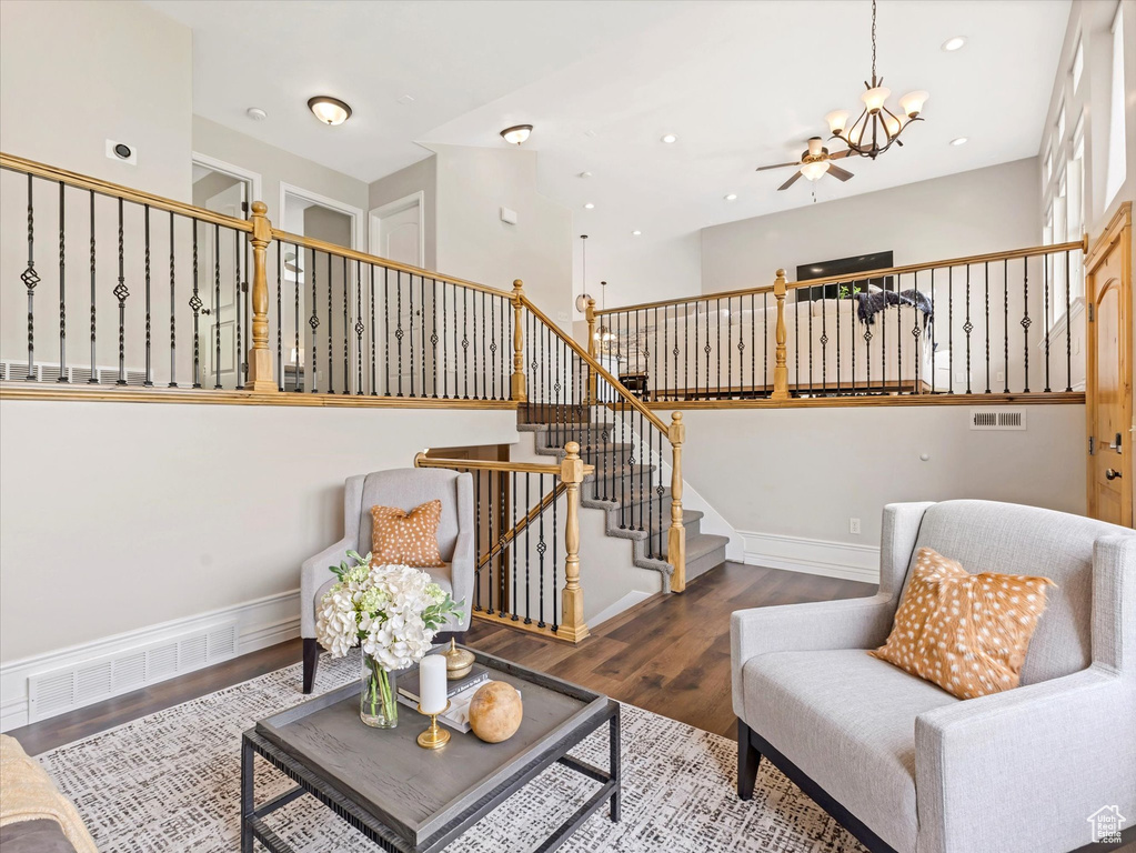 Living area with wood finished floors, a chandelier, stairs, baseboards, and recessed lighting
