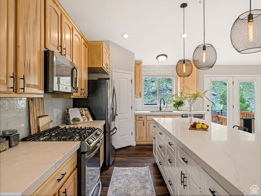 Kitchen with stainless steel appliances, a sink, dark wood finished floors, recessed lighting, and light stone countertops