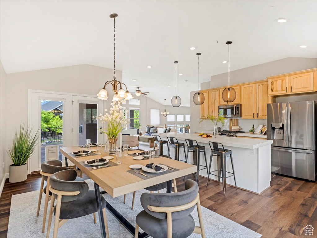 Dining area with vaulted ceiling, plenty of natural light, dark wood-style floors, a chandelier, and recessed lighting