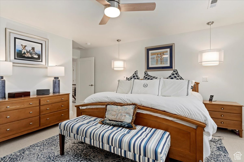 Bedroom with light colored carpet and a ceiling fan