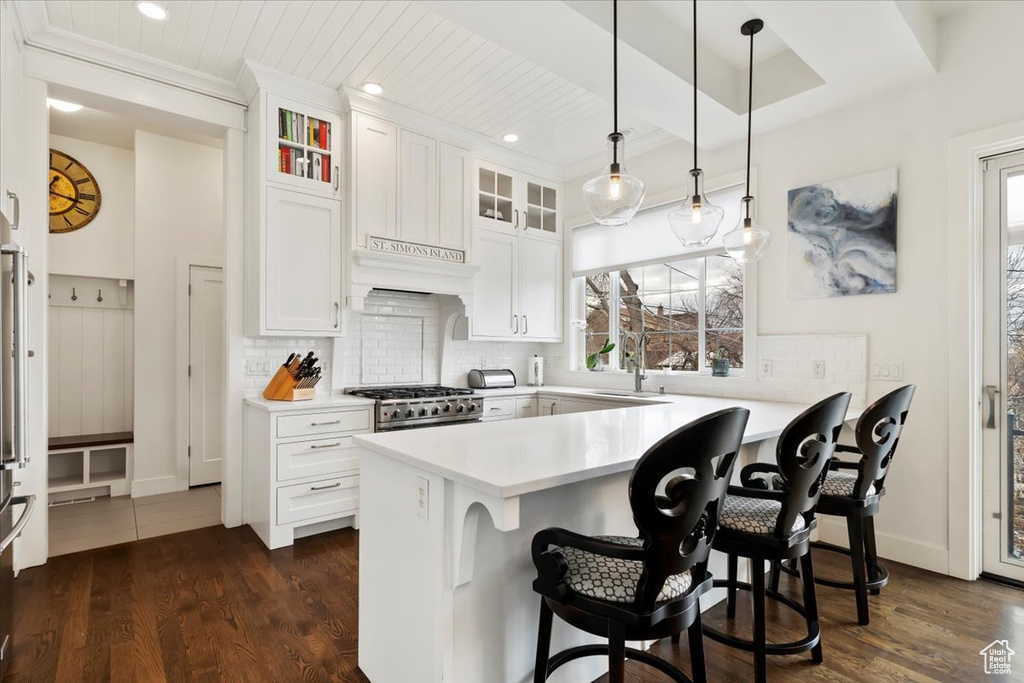 Kitchen featuring range, plenty of natural light, crown molding, decorative backsplash, and glass insert cabinets