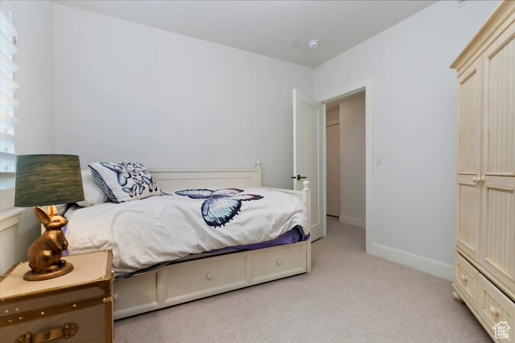 Bedroom with light colored carpet and baseboards