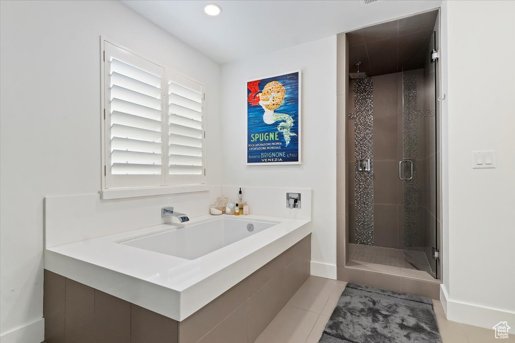 Bathroom with a shower stall, tile patterned flooring, baseboards, a sink, and a bath