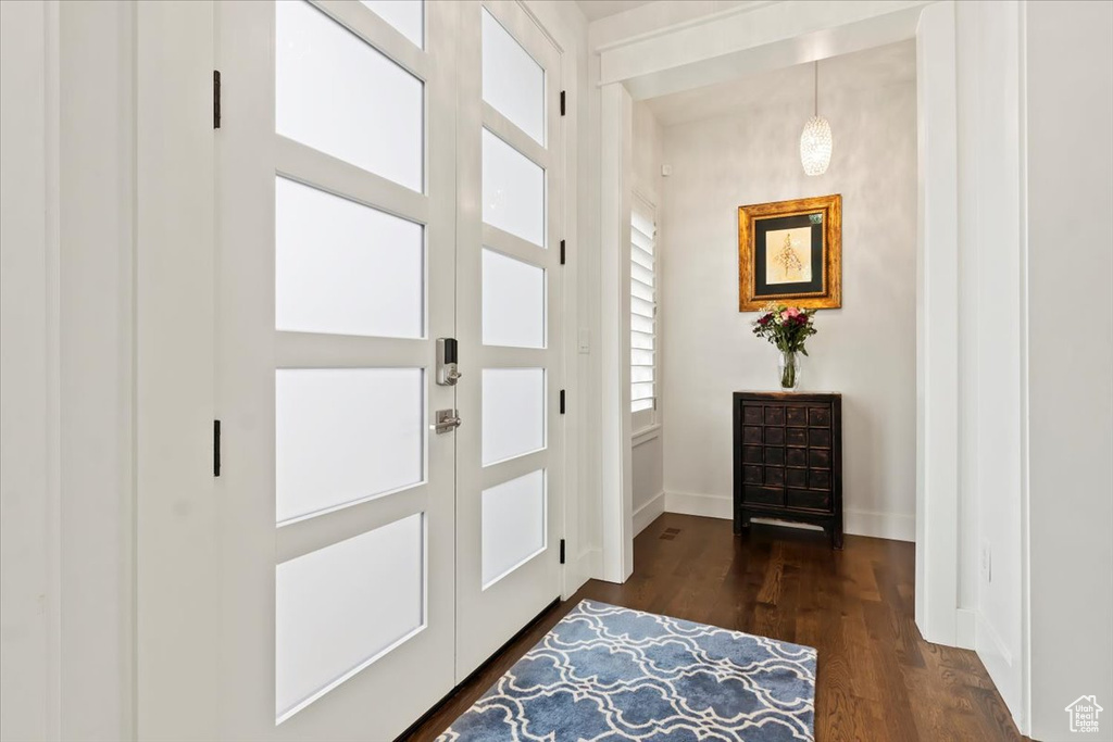 Foyer with baseboards and dark wood-style floors