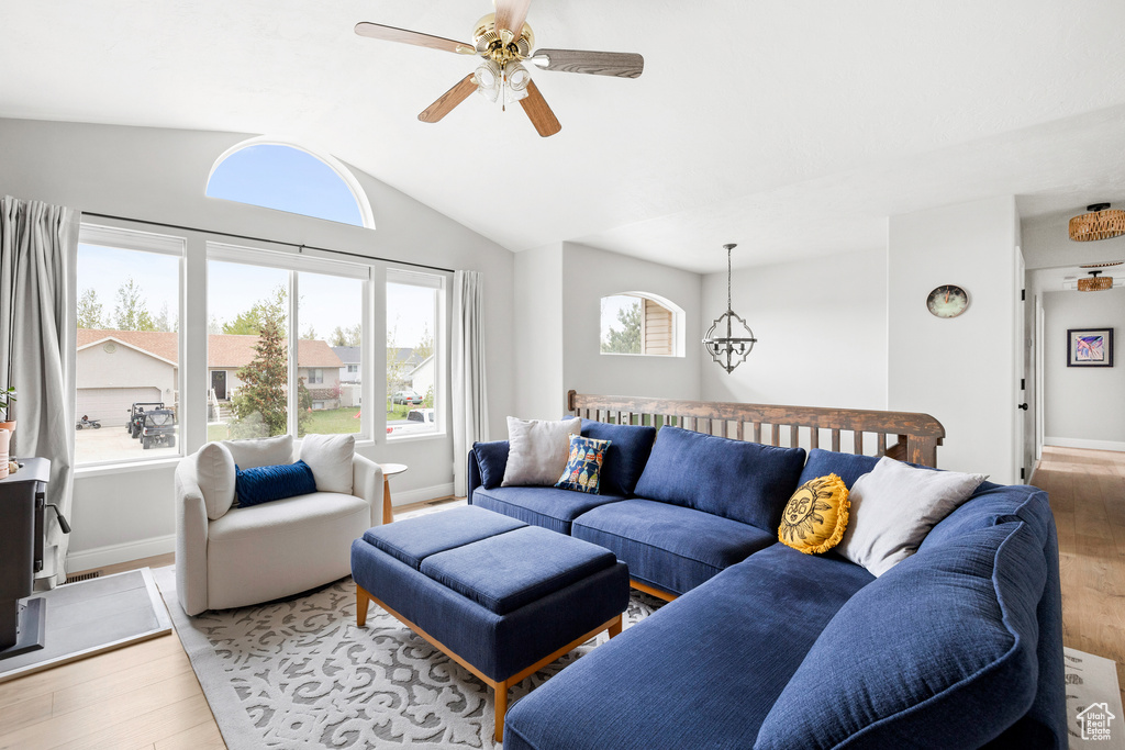 Living area with light wood-style flooring, ceiling fan, lofted ceiling, and baseboards