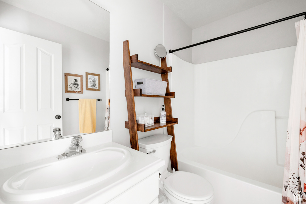 Bathroom with shower / tub combo, toilet, and vanity