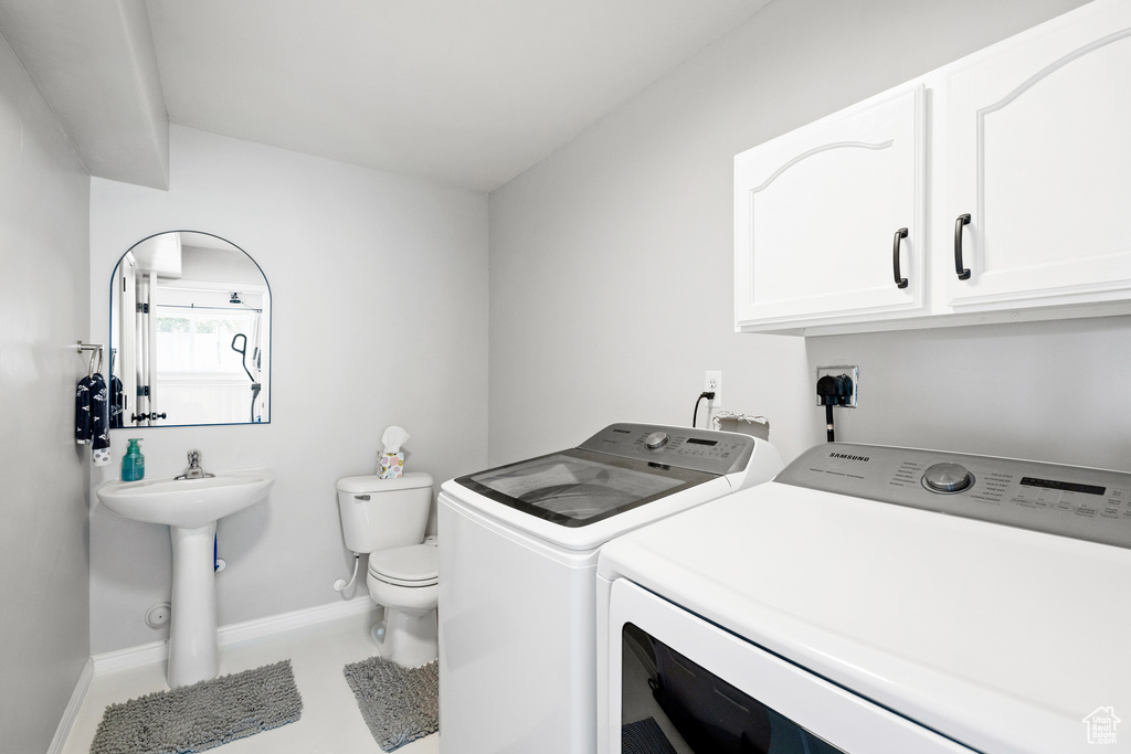 Laundry area with independent washer and dryer and baseboards