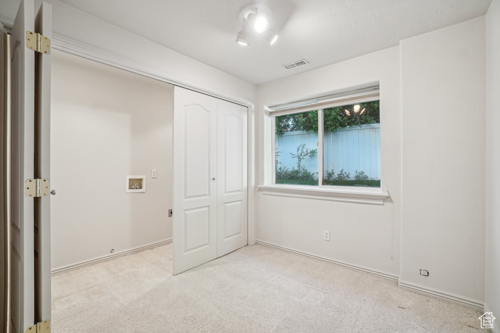 Unfurnished bedroom with light colored carpet, a closet, and baseboards