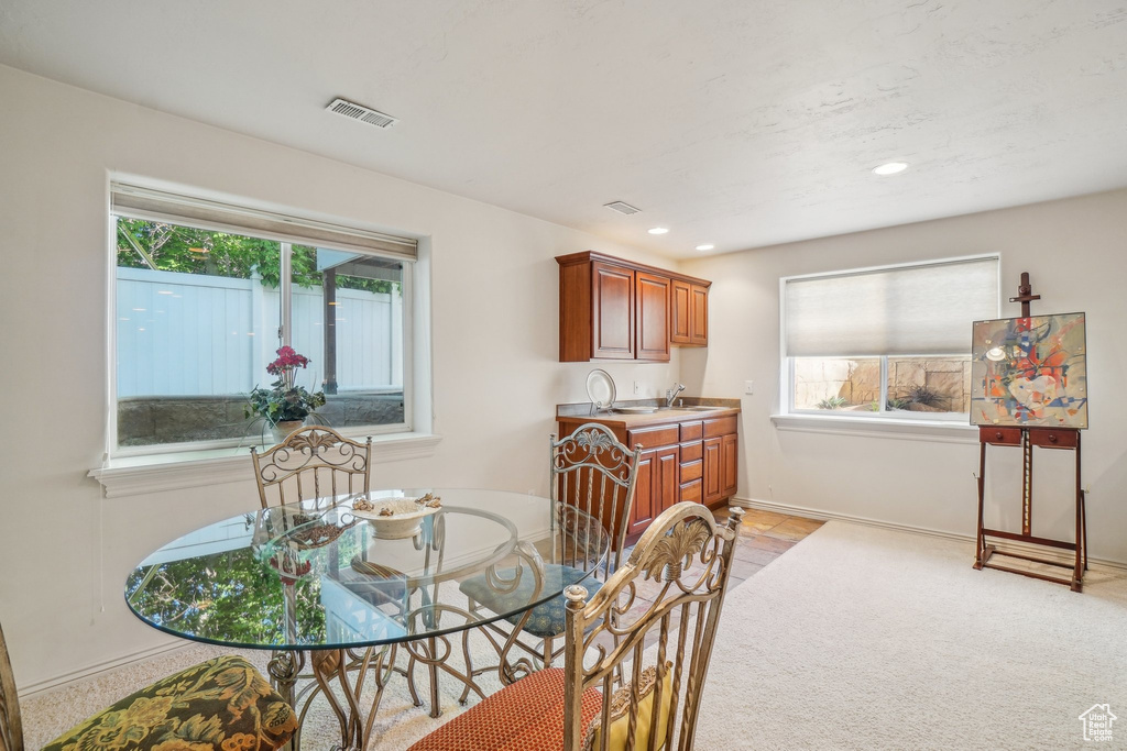 Dining room with light carpet, baseboards, and recessed lighting