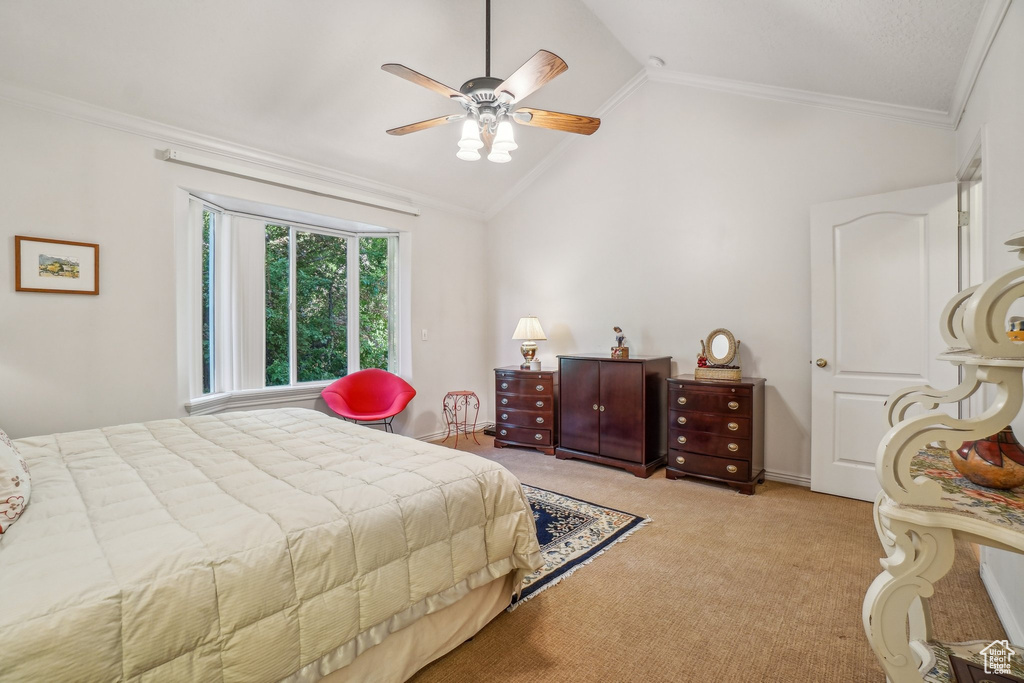 Carpeted bedroom with ornamental molding, vaulted ceiling, and a ceiling fan