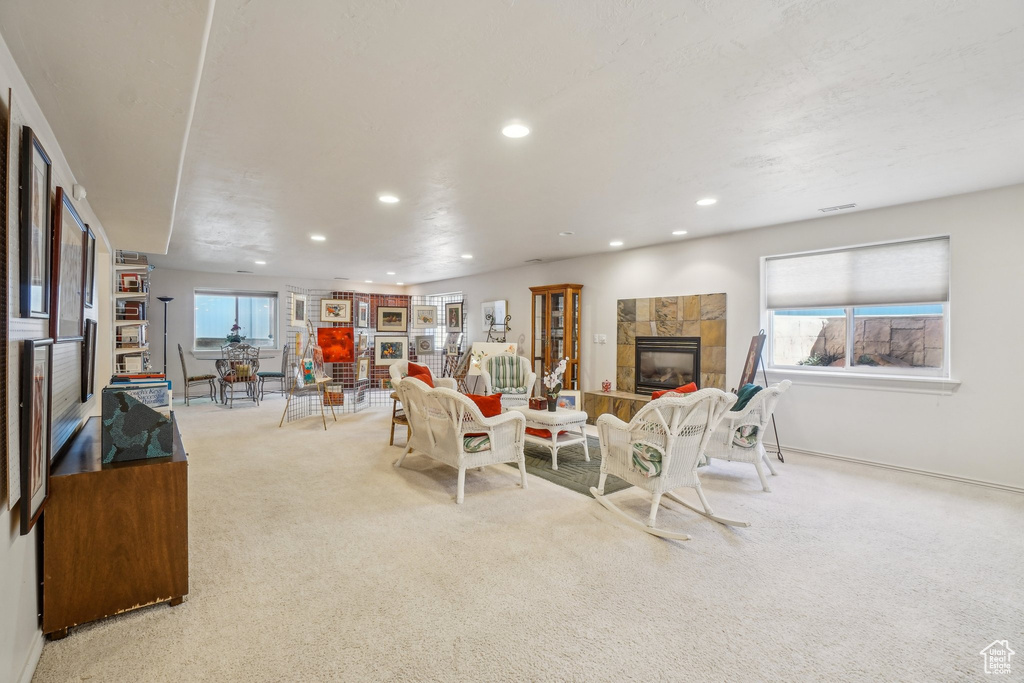 Carpeted living area featuring a tile fireplace, recessed lighting, and baseboards
