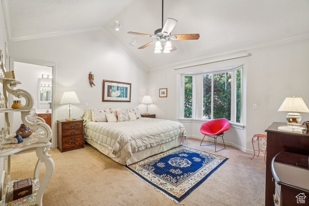 Bedroom featuring light colored carpet, vaulted ceiling, crown molding, baseboards, and ceiling fan