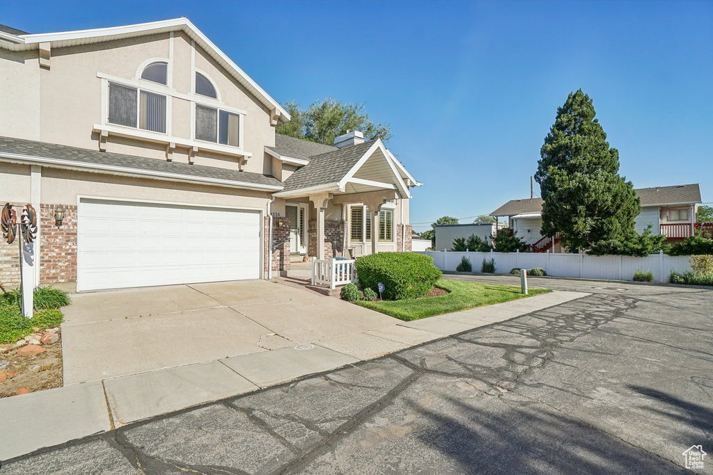 View of front facade with brick siding, concrete driveway, a garage, and stucco siding