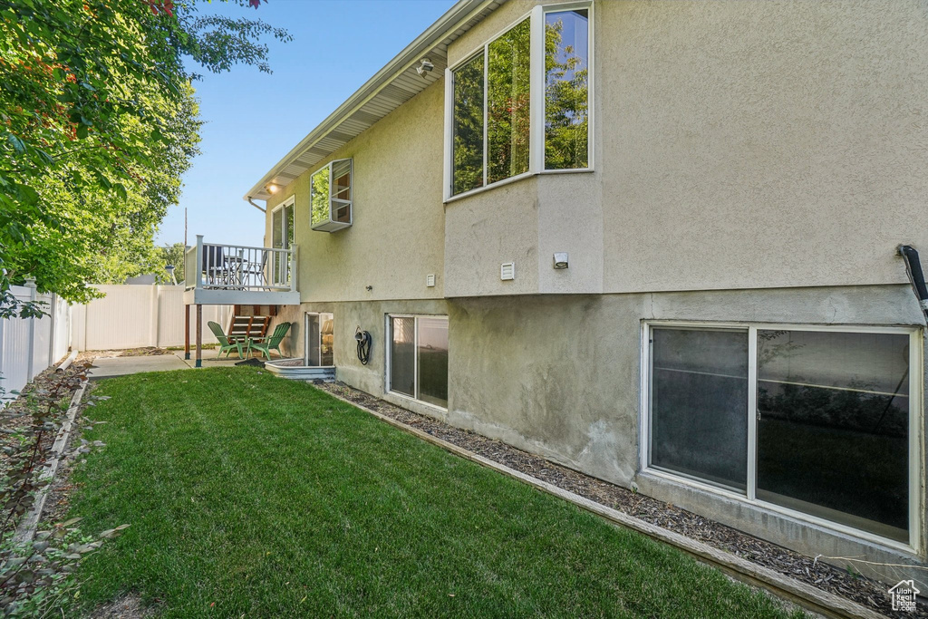Back of house with stucco siding, stairway, and a deck